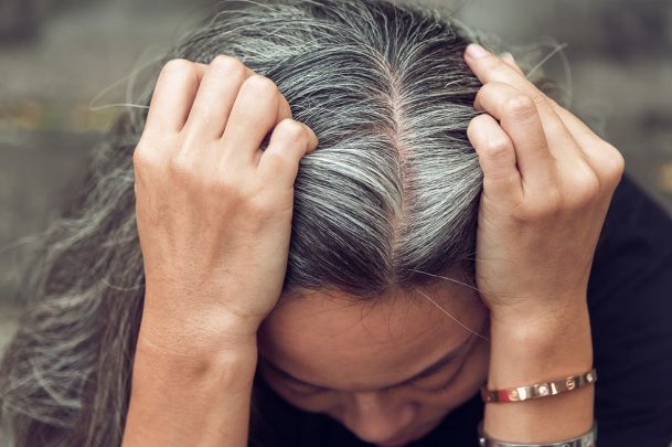 woman parting her gray hair down the middle