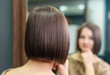 Woman with bob haircut looking at reflection in mirror