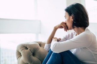 Woman sitting by window in thought