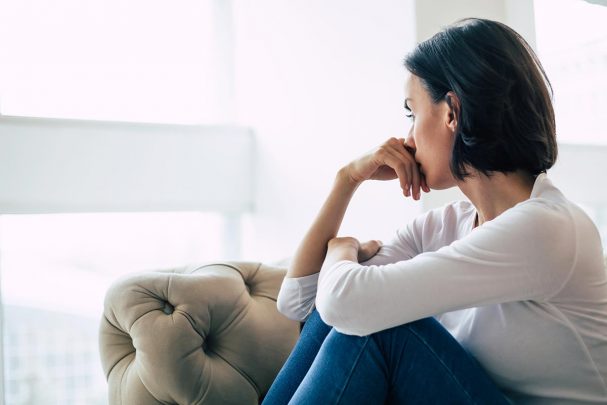 Woman sitting by window in thought